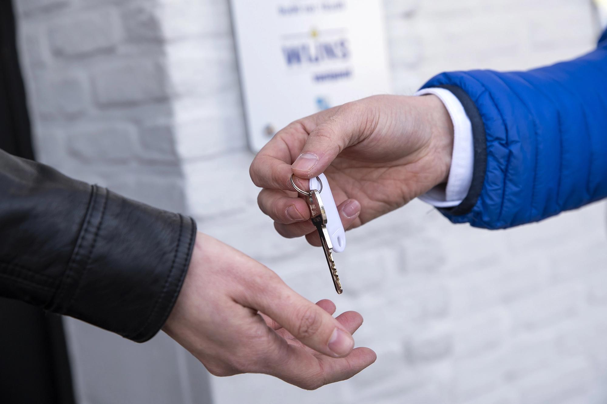 Makelaar overhandigt sleutel